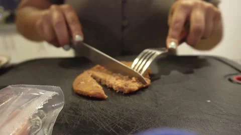 Closeup cutting a hamburger with a knife in the kitchen in 4k 動画素材 193005582