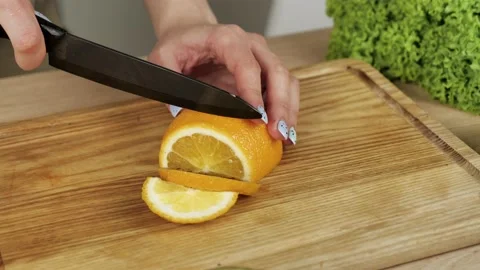 Closeup of cutting orange into small slices Stock Footage 150781431