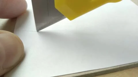 Closeup cutting a piece of paper using utility knife. Stock Footage 233368398