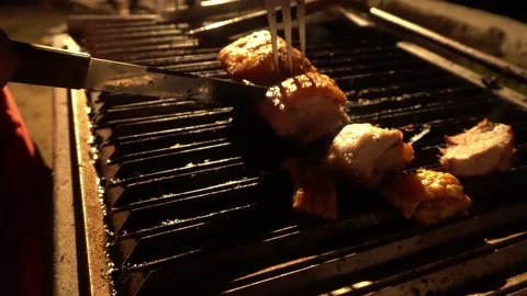 Closeup cutting pork to chinese box with knife and hands on grill with knife at Stock Footage 199532636