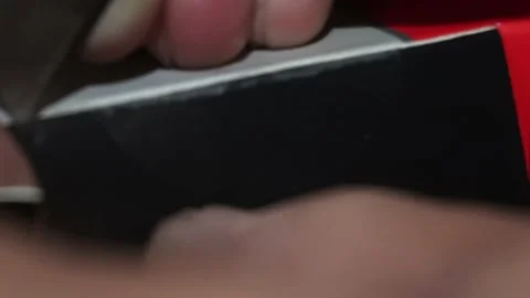 Closeup cutting a small seal from a box with a razor knife and hands Stock Footage 167245667