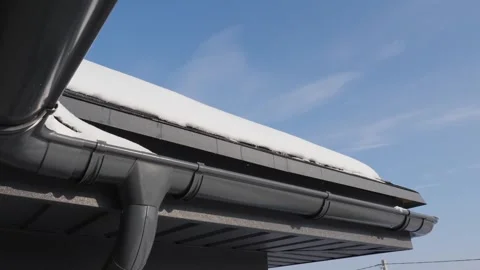 Closeup of dark grey gutter system installed on house roof edge with light .. Stock Footage 334993328