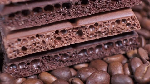 Closeup of dark roasted coffee beans and chocolate on rotating table. Stock Footage 140090499