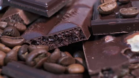 Closeup of dark roasted coffee beans and chocolate on rotating table. Stock Footage 140090960
