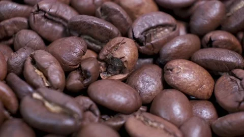 Closeup of dark roasted coffee beans on rotating table. Aromatic coffee grains a Video stock 140561851