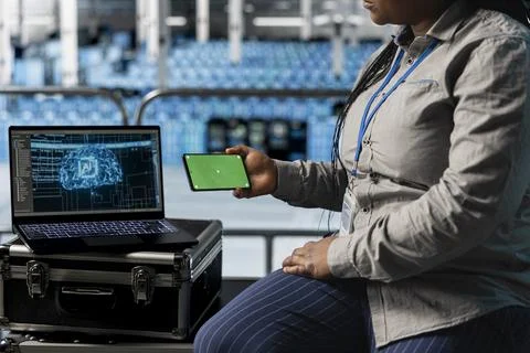 Closeup of data center admin using green screen smartphone and reviewing AI code Stock Photos