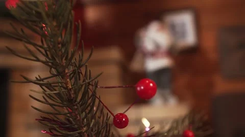 Closeup. Decor. Xmas tree red berries. Figurine of santa claus on the mantel. Stock Footage 144045977