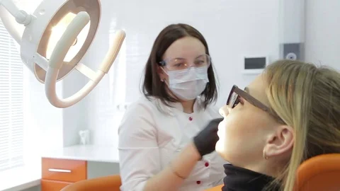 Closeup of dentist examining young woman's teeth. Stock Footage