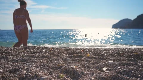 Closeup detail - small pebbles or rough sand on a beach, blurred afternoon .. Stock Footage 296395100