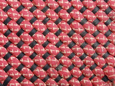 Closeup of a diagonal red thread pattern with red and white details on it 스톡 사진