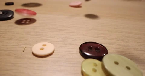 Closeup of different colorful sewing buttons falling on a wooden table. Fashi Stock-Footage 168248569