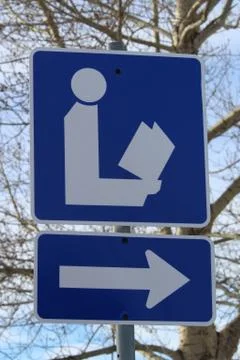 Closeup of Direction to Library Sign with Tree in Background Stock Photos