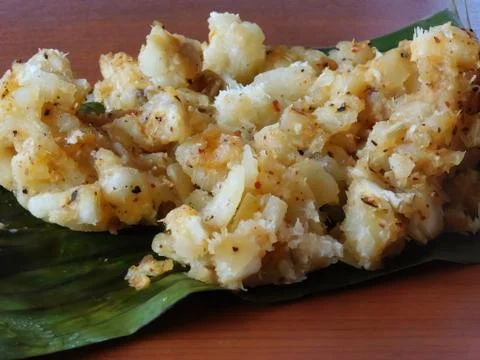 Closeup of a dish (tapioca curry) served on a banana leaf placed on the woode Stock Photos