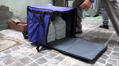 Closeup disinfecting with bleach a blue backpack with bagged food delivery on Stock Footage 156436746