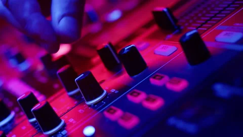 Closeup of DJs hands twisting knobs on mixing console adjusting volume of Video stock 170932940