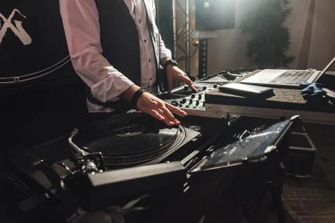 Closeup of DJ's hands at work. One hand operates gramophone, second adjusting Stock Photos