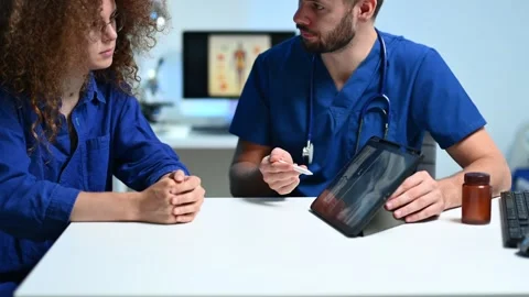 Closeup of doctor explaining knee X-ray on tablet to patient. and radiology.. Stock Footage 312383534
