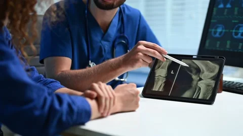 Closeup of doctor explaining knee X-ray on tablet to patient. and radiology.. Stock Footage 312383536