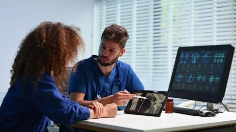 Closeup of doctor explaining knee X-ray on tablet to patient. and radiology.. Stock Footage 312383543