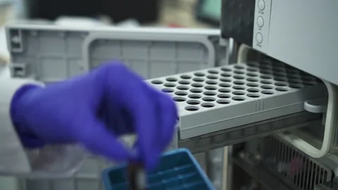 Closeup doctor scientist inserting bottles dna hiv blood test tubes in pcr Stock Footage