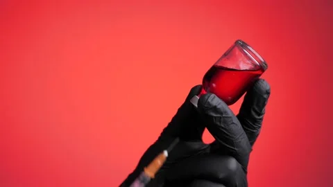 Closeup of doctor's hand in black gloves fill syringe on a red background. Stock Footage 131386650