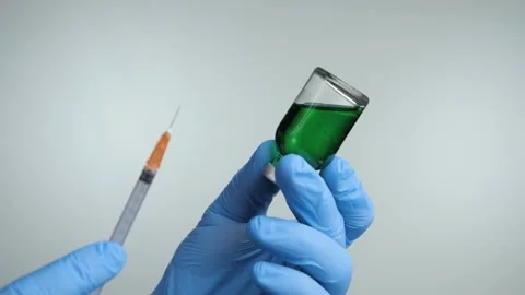 Closeup of doctor's hand in blue gloves fill syringe on a white background. Stock Footage 131386770