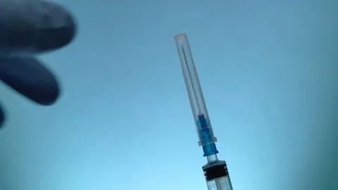 Closeup of doctor's hands in blue medical gloves remove the cap from the syringe Stock Footage
