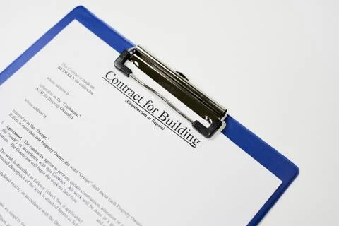 Closeup of a document entitled "Contract for building" on a blue clipboard Fotos de archivo