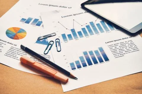 Closeup documents of Financial statistics dummy with graph, chart, tablet. Photos