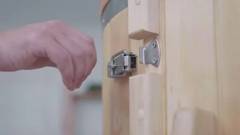 Closeup of door of cedar phytobarrel. Hand of master uses metal lock on latches Stock Footage 154002754