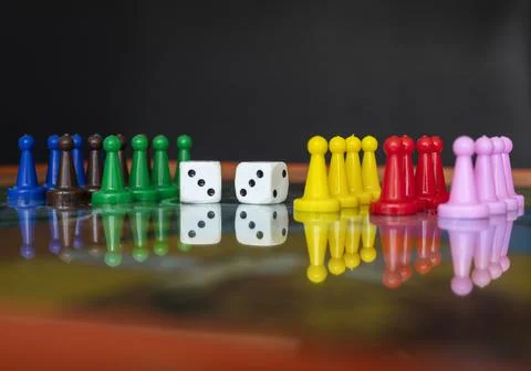 Closeup to a double three white dices with color pawns over a board game Stock Photos