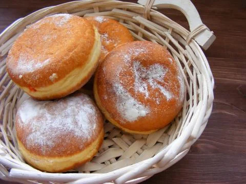 Closeup of doughnuts berliners on a bread basket on vintage wooden table Stock Photos