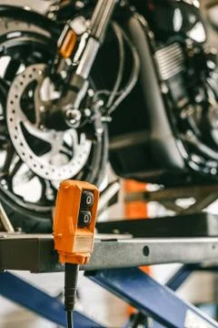 Closeup up down hydraulic controller switch on a lift with a motorcycle Stock Photos