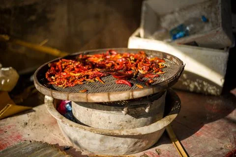 Closeup of dried chilies on dish stack in sunlight in Bangkok, Thailand 스톡 사진