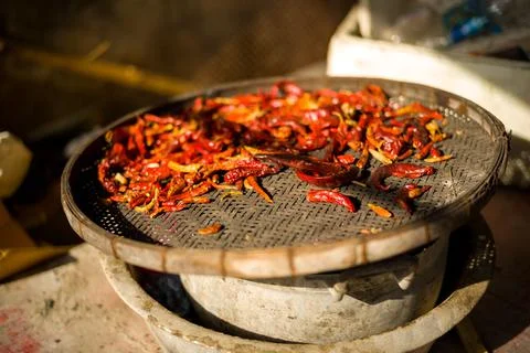 Closeup of dried chilies on dish stack in sunlight in Bangkok, Thailand Foto stock