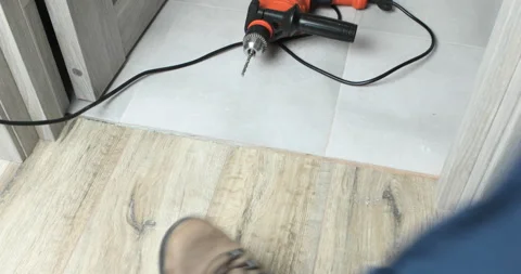 Closeup of a drill bit drilling a hole in a floor Stock Footage 108516783