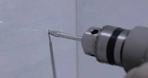 Closeup of a drill bit drilling a hole in a wall Stock Footage 129562171