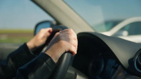Closeup of driver's hands on steering wheel while driving a car on a sunny .. Stock Footage 344408908