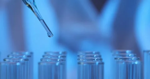 Closeup of drop falling into test tube in laboratory Stock Footage 284904620