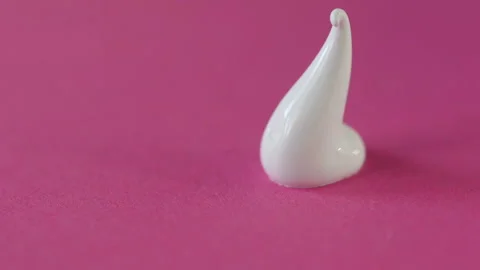 Closeup of a drop of white paint on a red background Stock Footage 101454708