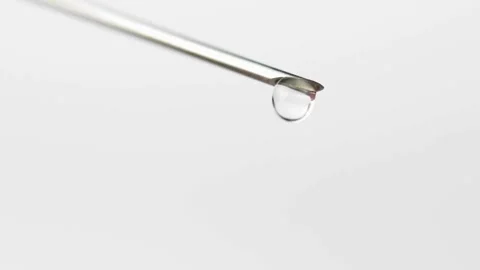 Closeup droplets of clear liquid fall and spurt from syringe medication medical Stock-Footage 336587269