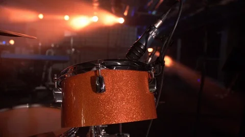 CLOSEUP OF DRUMS WITH MICROPHONE IN BEAUTIFUL ORANGE LIGHT Stock Footage 128315198