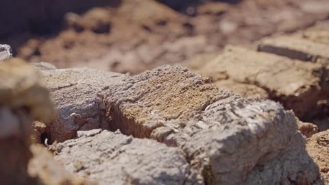 Closeup of dry peat chunks in sunlight as worker stacks blocks, slow motion Stock Footage 294697992