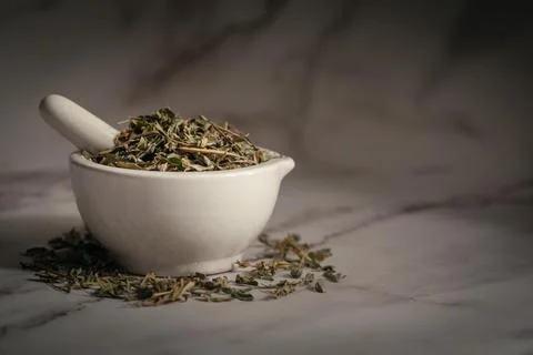 Closeup of  Dry Sharpunkha leaves, in white ceramic mortar and pestle. Stock Photos