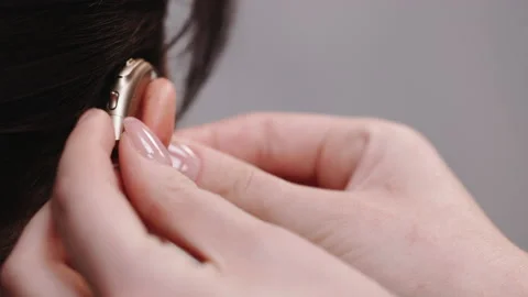 Closeup of ear with hearing aid, young deaf woman adjusting to environment Stock Footage 194848454