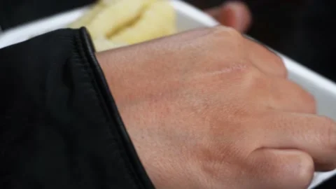Closeup eating corn with cheese with hands on a technopor plate Stock Footage 164549964