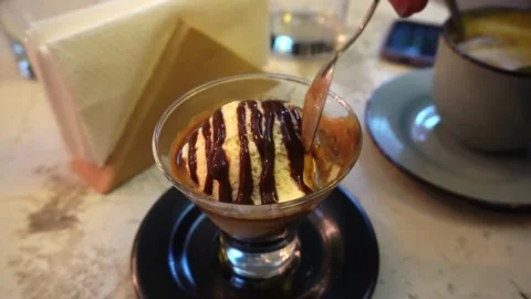 Closeup eating an ice cream cafe in a glass cup with a teaspoon in a cafeteria Stock Footage 166596341