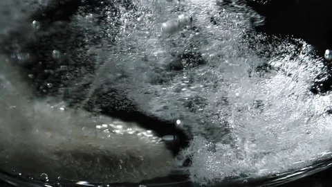 Closeup of effervescent tablet falling in a glass of water Video stock 81181556