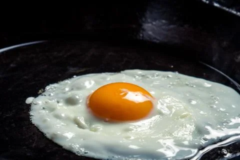 Closeup of eggs fried on a pan Stock Photos