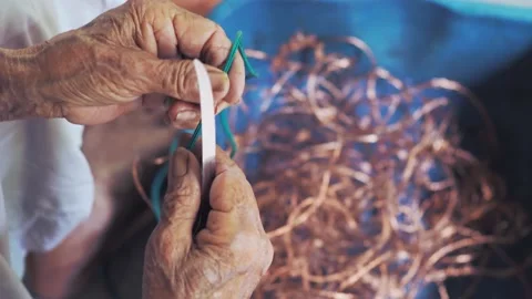 Closeup of elderly wrinkling hands remove copper from old wires plastic cover. Stock Footage